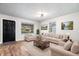 Bright living room boasts neutral tones, large windows, and comfortable seating arrangement with hardwood flooring at 3445 N Olney St, Indianapolis, IN 46218