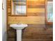 Close-up of bathroom featuring wood-paneled walls and a pedestal sink at 3721 S 575 W, Trafalgar, IN 46181