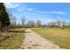 Gravel driveway leading to a home with mature trees and grassy lawns at 3721 S 575 W, Trafalgar, IN 46181