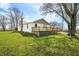 Exterior view of the property, featuring a wooden deck, grassy area, and mature trees at 3721 S 575 W, Trafalgar, IN 46181