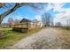 Home with a large wooden deck and gravel driveway surrounded by trees at 3721 S 575 W, Trafalgar, IN 46181