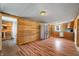Living room with wood paneled walls and stainless steel refrigerator, leading into kitchen and bathroom at 3721 S 575 W, Trafalgar, IN 46181