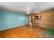 Living room featuring wood paneled walls, teal accent wall and wood laminate flooring at 3721 S 575 W, Trafalgar, IN 46181