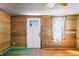 Living room featuring wooden walls, a bright white door, and natural light from a window at 3721 S 575 W, Trafalgar, IN 46181