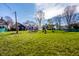 A spacious backyard with lush green grass, framed by a charming blue house at 3926 Rookwood Ave, Indianapolis, IN 46208