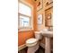 Cozy powder room featuring pedestal sink, floral artwork, and window at 3926 Rookwood Ave, Indianapolis, IN 46208