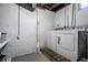 Basement laundry room featuring a standard washer and dryer on a raised wooden platform, and a textured white wall at 3926 Rookwood Ave, Indianapolis, IN 46208