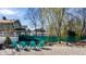 Backyard pond surrounded by trees and featuring Adirondack chairs on a gravel patio near green fence line at 3926 Rookwood Ave, Indianapolis, IN 46208