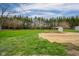 Large backyard featuring a shed, green grass, and wooded area at 3929 Lee St, Anderson, IN 46011