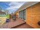 Outdoor wooden deck featuring a table, chairs, and a clear view of the backyard and blue skies at 3929 Lee St, Anderson, IN 46011