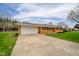 Traditional brick home featuring an attached two-car garage and a long driveway at 3929 Lee St, Anderson, IN 46011