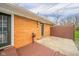 Back patio featuring brick wall, concrete, wooden fence and gate and partial wooden deck at 3929 Lee St, Anderson, IN 46011