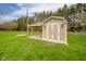 Well-maintained shed with a covered area, decorative lights, and gravel landscaping in backyard at 3929 Lee St, Anderson, IN 46011
