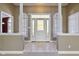 Bright foyer featuring tiled floors, decorative glass door, and half-wall columns at 400 S Prairie Trce, Muncie, IN 47304