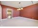 Living room featuring neutral carpeting, unique lighting, and warm colors at 400 S Prairie Trce, Muncie, IN 47304