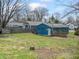 View of the backyard and detached garage, surrounded by a wooden fence and grassy lawn at 5006 W Naomi St, Indianapolis, IN 46241