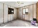 Bedroom needing remodel showcases dual windows, wood paneling, and ceiling fan at 5006 W Naomi St, Indianapolis, IN 46241