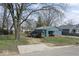 Blue home surrounded by trees; property includes grass and a driveway at 5006 W Naomi St, Indianapolis, IN 46241