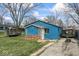 A compact blue home featuring a brick accent wall and well-worn driveway at 5006 W Naomi St, Indianapolis, IN 46241