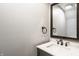 A powder room offers a pedestal sink with a decorative mirror and a charming towel ring at 503 Lockerbie N Cir, Indianapolis, IN 46202