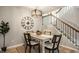 A charming dining area with an elegant light fixture and classic furnishings sits adjacent to a stairway at 503 Lockerbie N Cir, Indianapolis, IN 46202