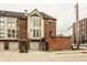 Brick townhome featuring attached garages and well-maintained landscaping with an inviting facade at 503 Lockerbie N Cir, Indianapolis, IN 46202