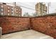 Enclosed brick patio featuring concrete and room for outdoor decor, with buildings in the background at 503 Lockerbie N Cir, Indianapolis, IN 46202