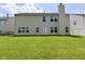 View of the backyard with lush lawn, exterior of the home, and chimney at 5565 Noble Dr, Indianapolis, IN 46234