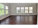 Open living room features large windows with backyard views and rich hardwood floors at 5565 Noble Dr, Indianapolis, IN 46234