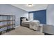 This bedroom features blue accent walls, a comfortable bed, shelving, and a bright window at 714 Breakers Ln, Fortville, IN 46040