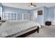Spacious primary bedroom with blue walls, ceiling fan, large bed, and natural light at 714 Breakers Ln, Fortville, IN 46040