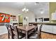 Open concept kitchen featuring granite counters, white cabinetry, breakfast bar, and hardwood flooring at 714 Breakers Ln, Fortville, IN 46040