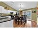 Eat-in kitchen with white cabinets, black countertops, stainless appliances, and dark wood dining set at 714 Breakers Ln, Fortville, IN 46040