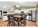 Bright eat-in kitchen with white cabinets, stainless appliances, breakfast table, and hardwood flooring at 714 Breakers Ln, Fortville, IN 46040