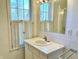 Small bathroom with square tiled walls, vanity with sink, and window with shutters at 7180 N State Road 42, Eminence, IN 46125