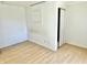 Empty bedroom with white walls and a light-colored hardwood floor with a small closet at 7180 N State Road 42, Eminence, IN 46125