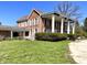Brick home featuring a grand colonnade, inviting covered areas and mature trees at 7180 N State Road 42, Eminence, IN 46125