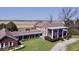 Sprawling brick home featuring a pillared porch, lush lawn, and open field views at 7180 N State Road 42, Eminence, IN 46125