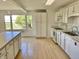 Bright kitchen featuring white cabinets, ample counter space, modern appliances, and a window view at 7180 N State Road 42, Eminence, IN 46125