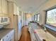 Galley kitchen with white cabinets, hardwood flooring, and lots of natural light at 7180 N State Road 42, Eminence, IN 46125