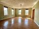 A spacious living room with hardwood floors, lots of windows, green striped wallpaper and a decorative light fixture at 7180 N State Road 42, Eminence, IN 46125