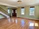 Formal living room boasts beautiful hardwood floors, a staircase, and green striped wallpaper at 7180 N State Road 42, Eminence, IN 46125