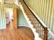 A view of a curved staircase with wood handrail and carpeted steps leading to the second floor of the home at 7180 N State Road 42, Eminence, IN 46125
