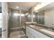 Ensuite bathroom featuring dual sinks, gray countertops, and an enclosed shower with glass doors and tiled walls at 7247 Barker St, Carmel, IN 46033