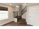 Welcoming entryway featuring dark vinyl flooring, iron railing staircase, and a bright front window at 7247 Barker St, Carmel, IN 46033