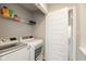Convenient laundry room equipped with modern washer and dryer and shelf for storage at 7247 Barker St, Carmel, IN 46033