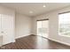 Spacious living room with wood flooring, neutral walls, two windows and sliding glass door leading to outdoor balcony at 7247 Barker St, Carmel, IN 46033