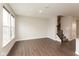 Open living area with wood floors, natural light from window, and staircase leading to the second level at 7247 Barker St, Carmel, IN 46033