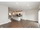 Open-concept living space showcasing wood floors, white cabinets, an island and stainless appliances in the kitchen at 7247 Barker St, Carmel, IN 46033
