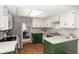 Bright kitchen with white and green cabinetry, stainless steel appliances, and granite countertops at 797 Crossbridge Ct, Avon, IN 46123